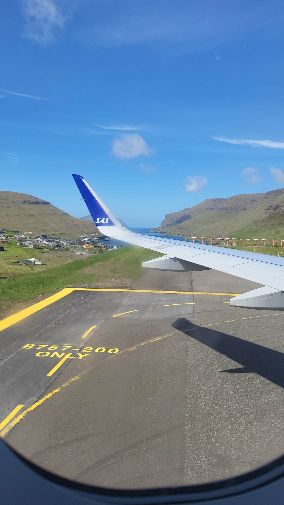 Plane wing and Faroese views through the plane window just after landing