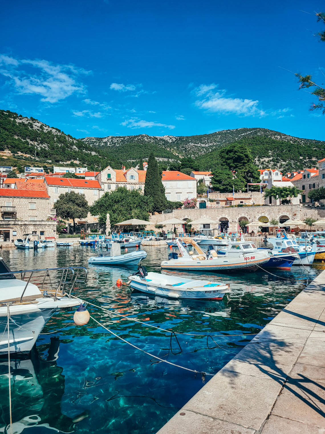 Small boats in Bol harbours, Brac island and view of mountains in the back