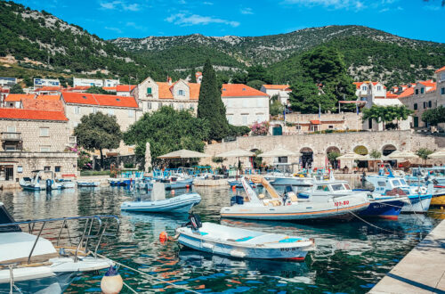 Small boats in Bol harbours, Brac island and view of mountains in the back