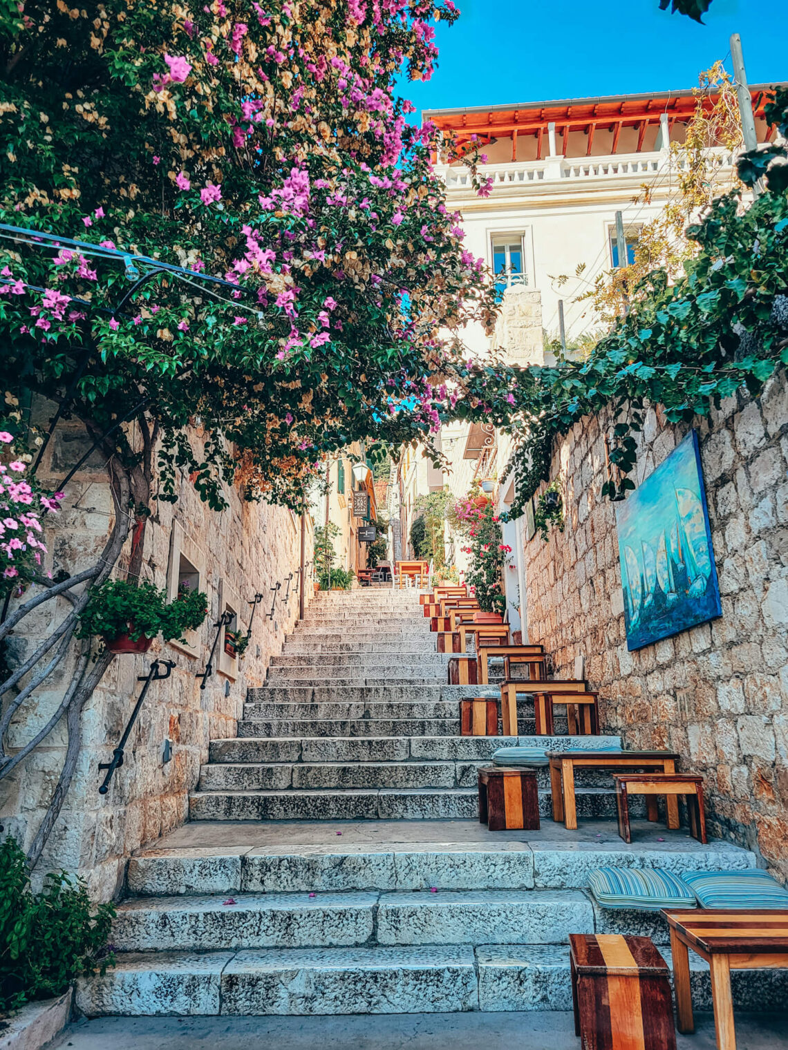 Cobblestone steps in one of the streets in Hvar, with tables and a lot of flowers